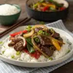 Sizzling Chinese pepper steak with onions on a plate.