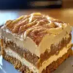 Pumpkin spice gooey cake with cream cheese frosting served on a plate