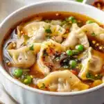 Bowl of steaming Potsticker Soup with dumplings and fresh herbs